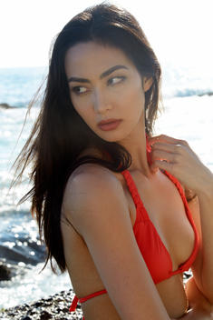 Asian model in red bikini at the beach.