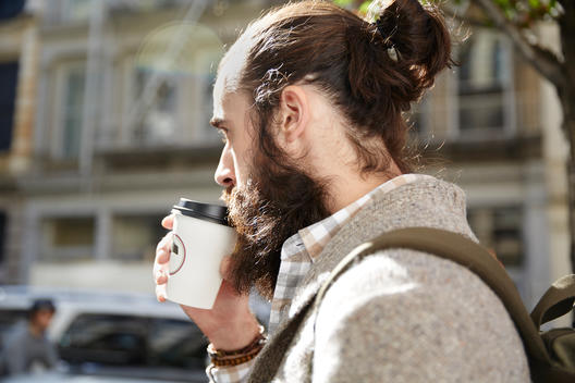 Young man in city drinking coffee