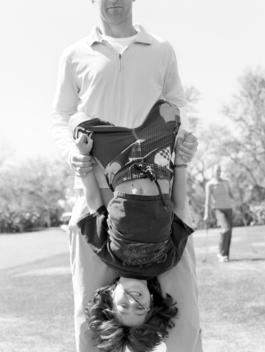 A Father Holds His Son Upside Down.