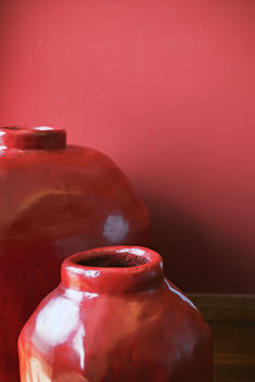 Chinese big red jar in front of red wall