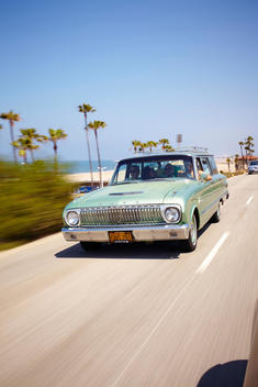 An old car driving by the ocean