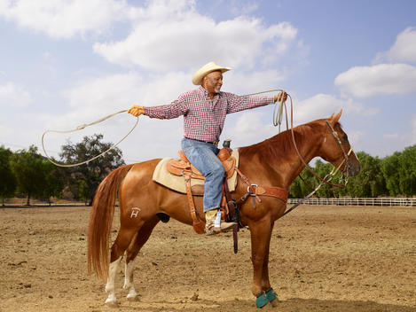 Actor James Pickens, Jr. throws a lasso as he sits on his horse at a ranch