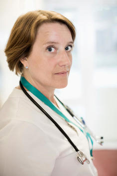 Side view portrait of mature female doctor standing in hospital