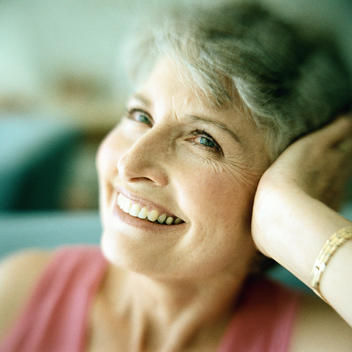 Portrait of mature woman smiling with head resting in hand