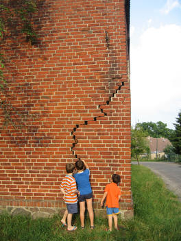 Three Boys Looking At A Hole In The Wall