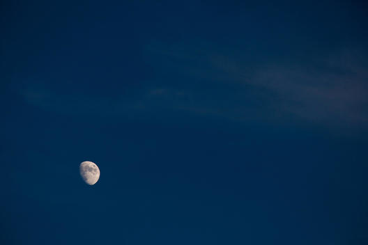 The moon seen at dusk in the capital city of Lisbon, Portugal