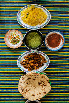 Plates of Yemeni food on striped tablecloth