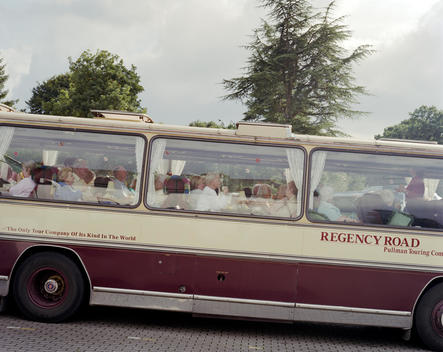 A group of elderly tourists sit having afternoon tea on their coach during a trip to Bowness-on-Windermere in the Lake District.
