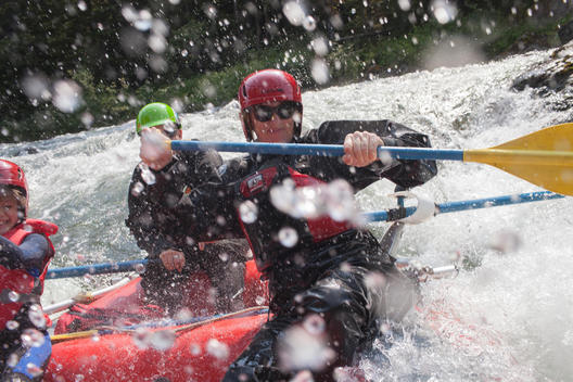 three people getting wet on a white water raft at Clayoquot Wilderness Resort