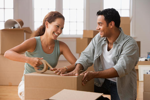 Hispanic couple packing moving boxes