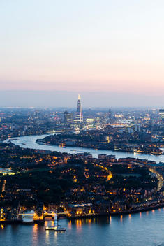 Rooftop dusk view from One Canada Square Tower looking east. River Thames and The Shard in the background. Canary Wharf