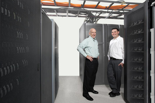 Two Men in a Server room with cables overhead