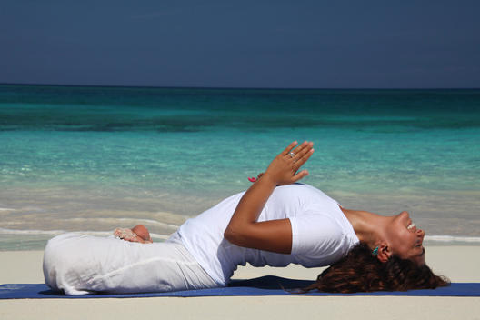 Young woman on beach doing yoga, Paradise Island, Nassau, Bahamas