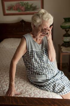 Elderly woman crying on bed, USA, California, South Pasadena
