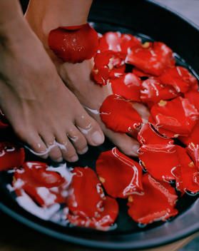 woman washing feet in rose petals