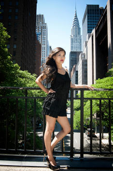 Asian woman in black dress in NYC, Chrysler Building in background