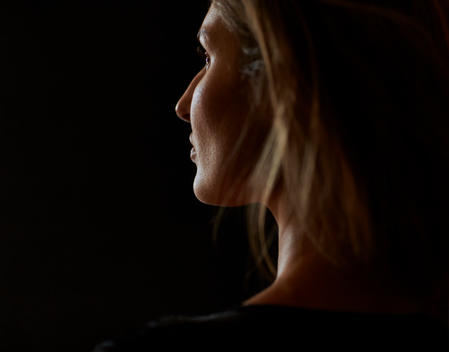 Profile of woman in the dark with edge light