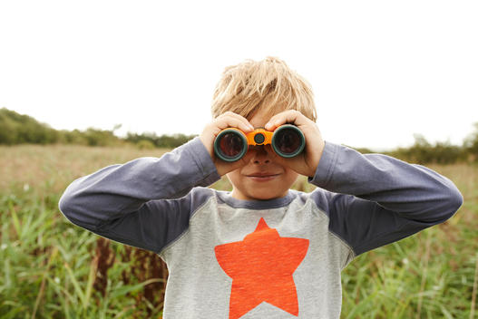 boy looking trough a binocular