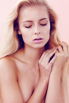 Closeup up of blonde model in bare skin and light natural makeup with pink lips