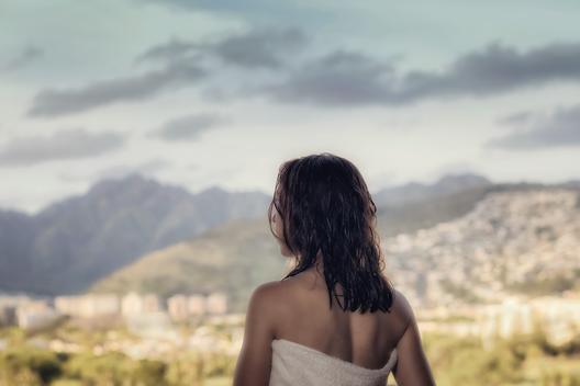 Woman in towel taking in view from balcony