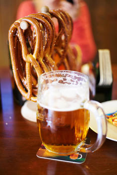 Mug of beer and hard pretzels hanging on table in a bar in Prague.