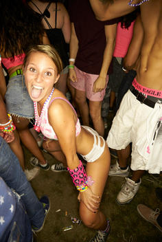 A woman in rave attire dancing in a group of people.