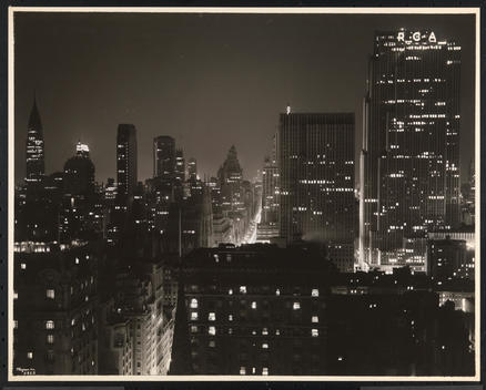 The R.C.A. Building And Rockefeller Center In The New York Skyline At Night, Looking South From The Hecksher Building With Chrysler Building At Far Left.