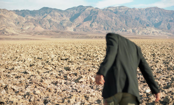 Headless Guy In Jacket With Back To Camera In Badwater Basin Death Valley, Out Of Focus