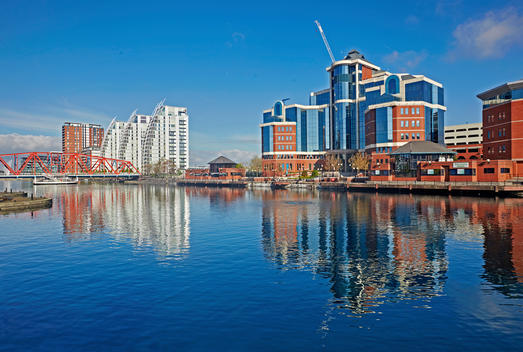Redeveloped modern architecture reflected in the redeveloped Salford Quays overlooking the Manchester Ship canal during sunrise with Erie Basin
