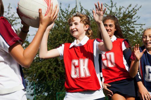 Schoolgirl netball players defending