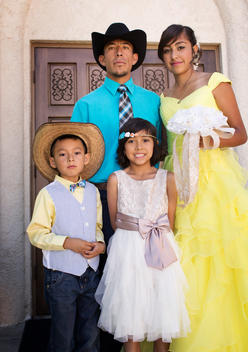 Hispanic family celebrating quinceanera outside Catholic church