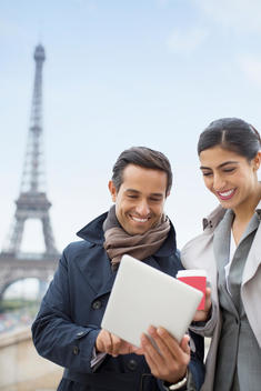 Business people using digital tablet near Eiffel Tower, Paris, France