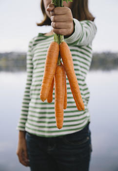 Nine year old girl holding organic carrots
