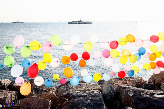 The State Owned Ferry Boat Is Coming From The Princess Island`S And Passing By The Bunch Of Colorfull Balloons By The Shore In Istanbul.