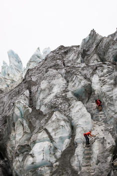 Two Glacier Guides Using Ice Picks To Carve Steps On Terminal Face Of Franz Josef Glacier