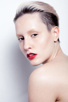 beauty image of model in studio, clean skin, short hair and red lips