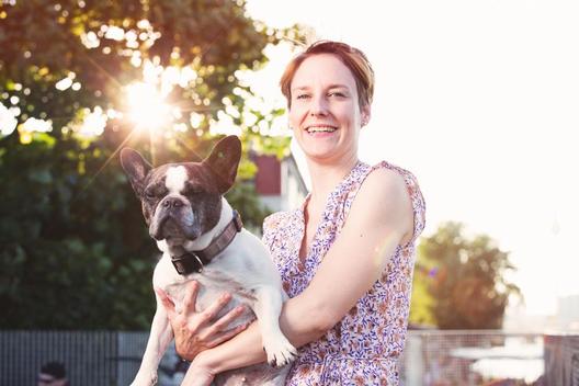 Portrait of smiling woman holding French bulldog
