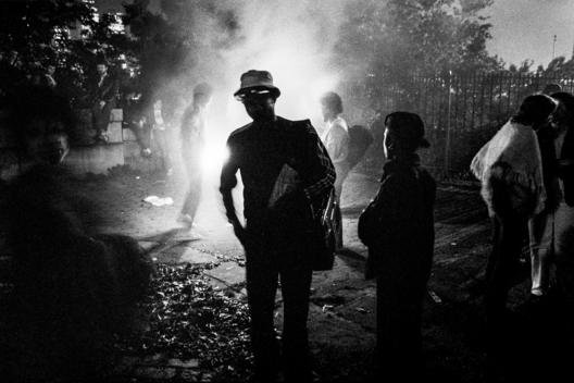 Bonfire alights behind person listening to boom box, Brooklyn Promenade, Brooklyn, NY celebration on May 24th, 1983