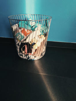 Laundry basket being hit by ray of sunlight in front of a blue wall