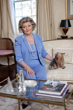 Portrait Of An Elegant Senior Woman Sitting With Her Yorkshire Terrier In Her Living Room