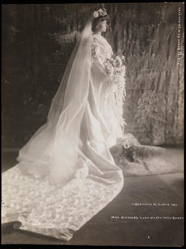 Alice Roosevelt Longworth Standing In Her Wedding Dress In A Profile View To Show Off The Train At The White House In Washington D.C. Her Bouquet Is Visible And She Stands In Front Of A Curtain.