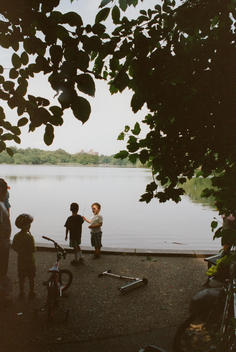 Young boys by the water\'s edge in Prospect Park, Brooklyn, New York