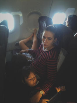 Mother traveling with young kids on the plane
