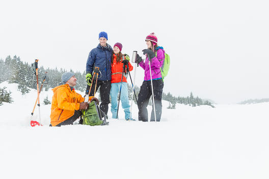 Two young couples taking a break during their snowshoeing adventure