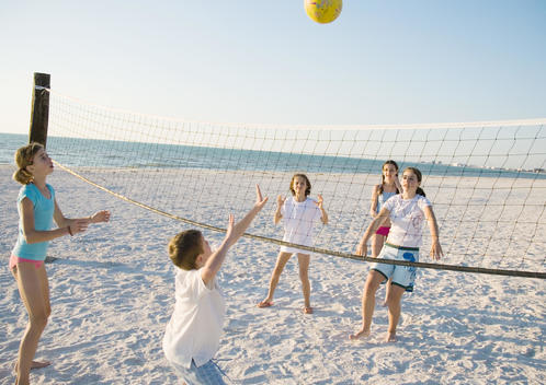Group of kids playing beach volleyball