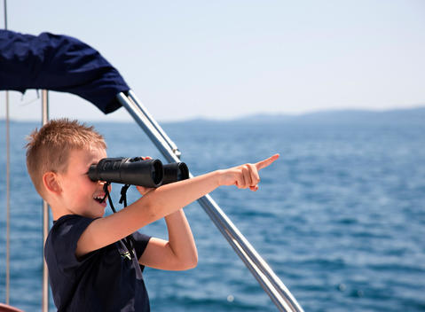 Croatia, Zadar, Boy looking through an binocular from sail boat