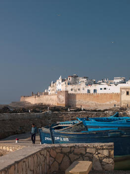 Fishing boats moored at the dock near the fortified sea wall protecting the medina at Essaouira, Morocco