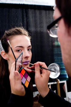 Fashion Model Having Makeup Applied Backstage At Runway Show