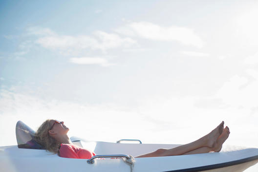 Woman reclining on yacht, Wales, UK