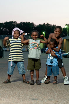 Group Of Boys Of African-American Appearance Playfully Posing In A Parking Lot